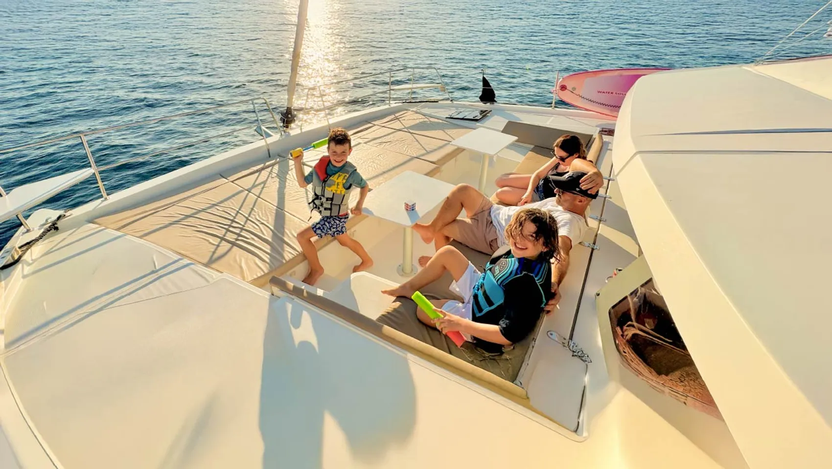 Family relax on the front of a catamaran