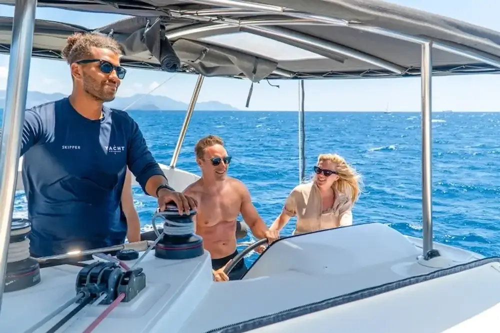 A Yacht Getaways skipper shows a couple how to sail on their luxury catamaran holiday.