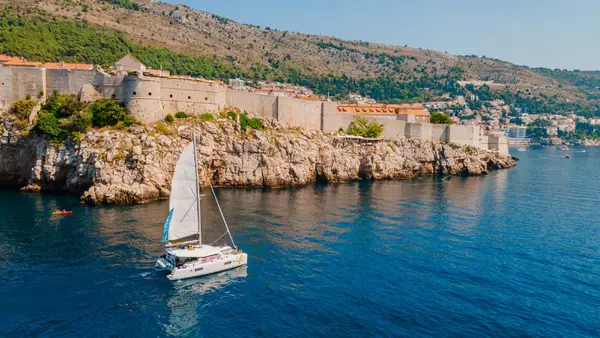 Catamaran sailing in front of Dubrovnik Old Town in Croatia