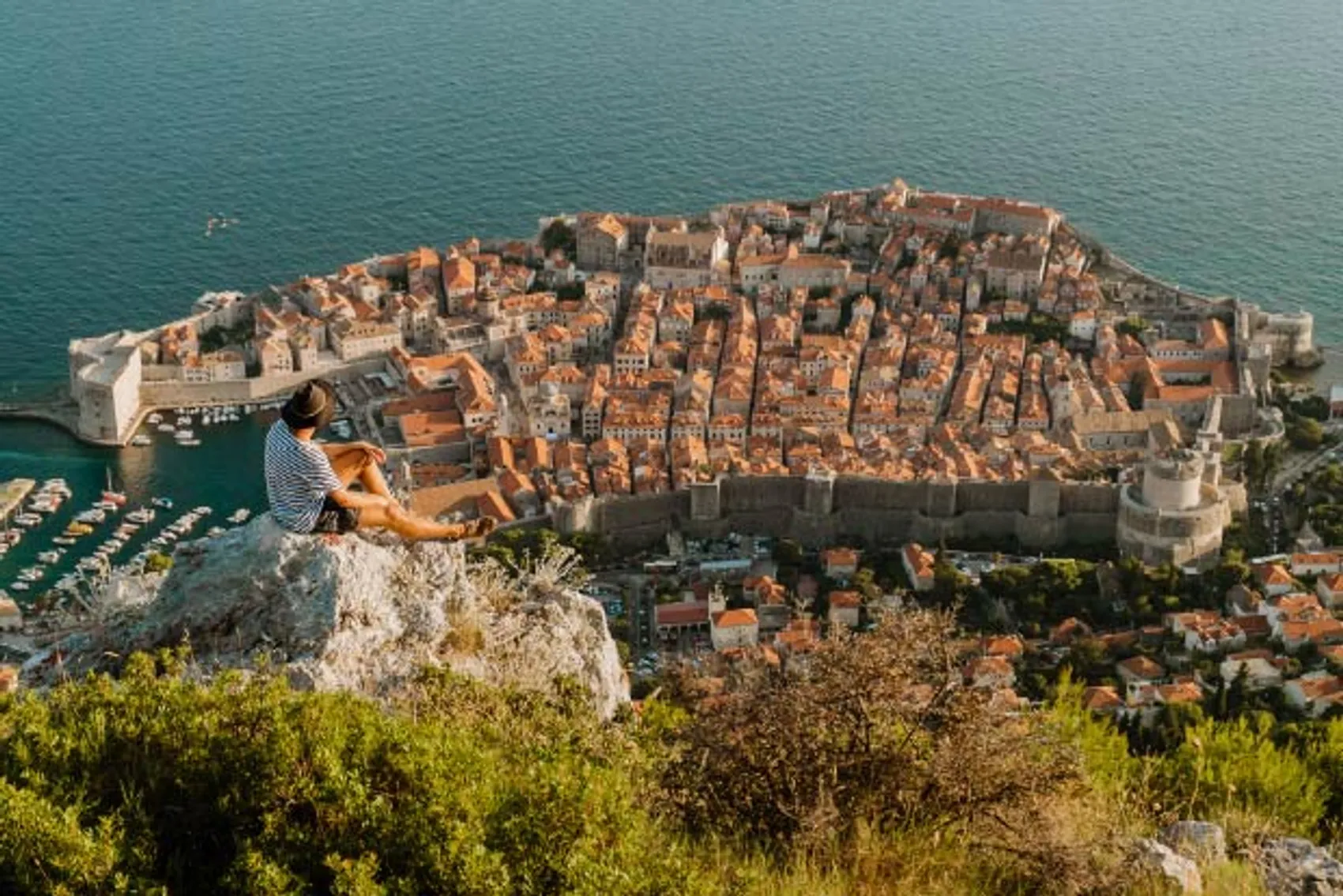 Person admires the view from above Dubrovnik Old Town in Croatia