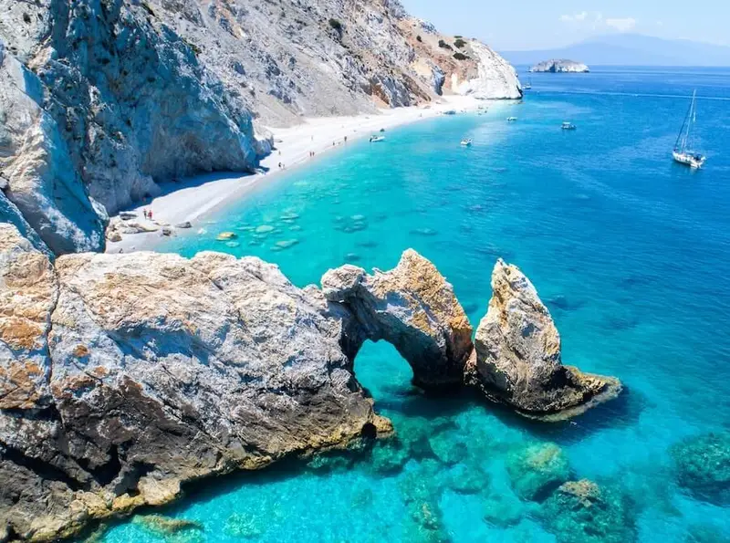 Aerial view of turquoise waters and sea cliffs along Lefkada and Ithaka in the Ionian Islands, Greece, with sailing yachts anchored offshore — a breathtaking highlight of luxury catamaran cruises with Yacht Getaways.