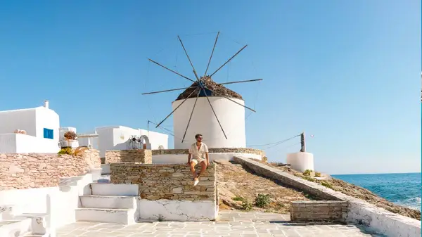 Man sitting in front of a windmill in Koufonisia