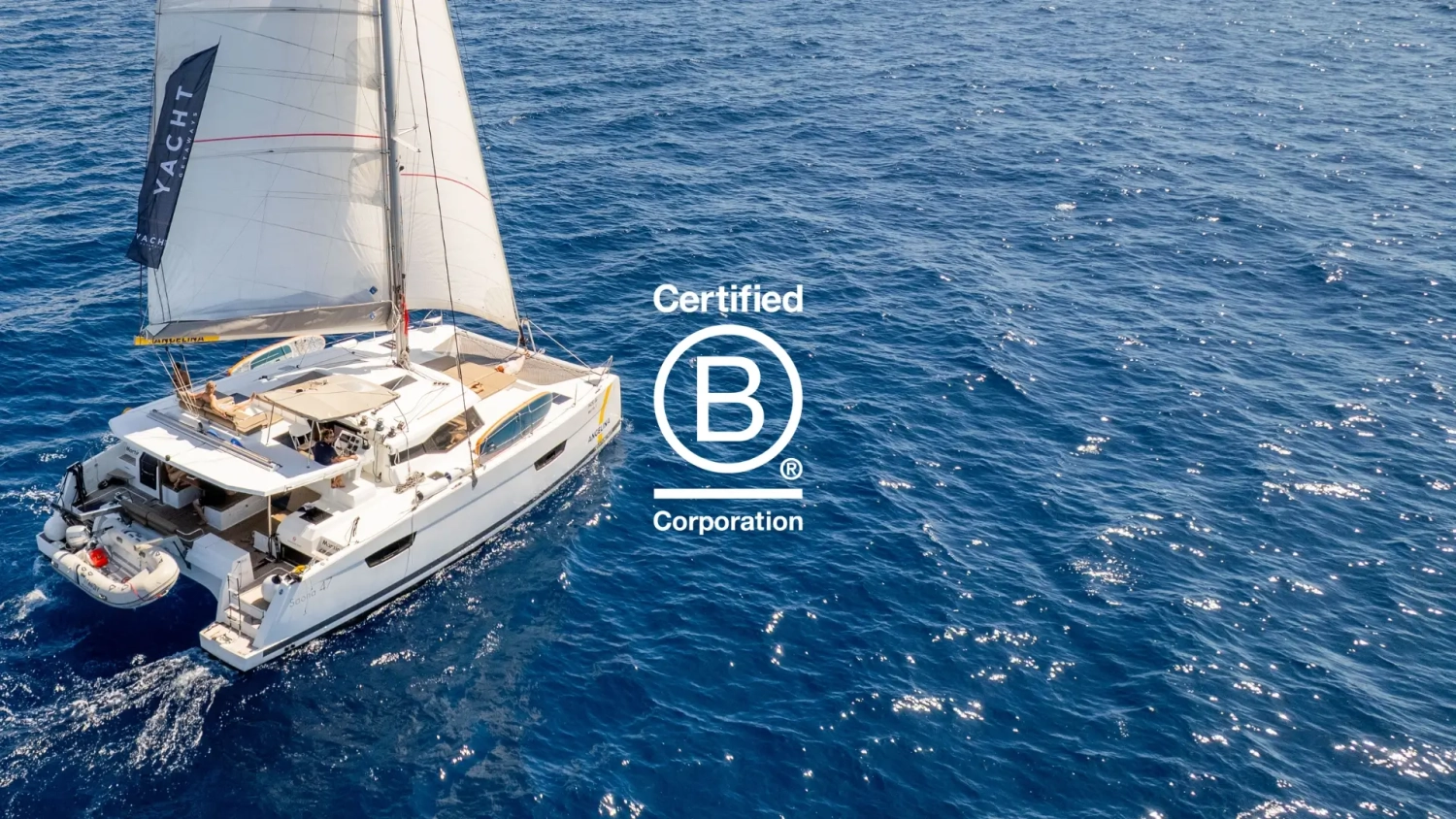 Yacht Getaways catamaran sailing on the Mediterranean Sea with Certified B Corp logo, announcing B Corp certification for responsible luxury sailing holidays in Greece and Croatia.