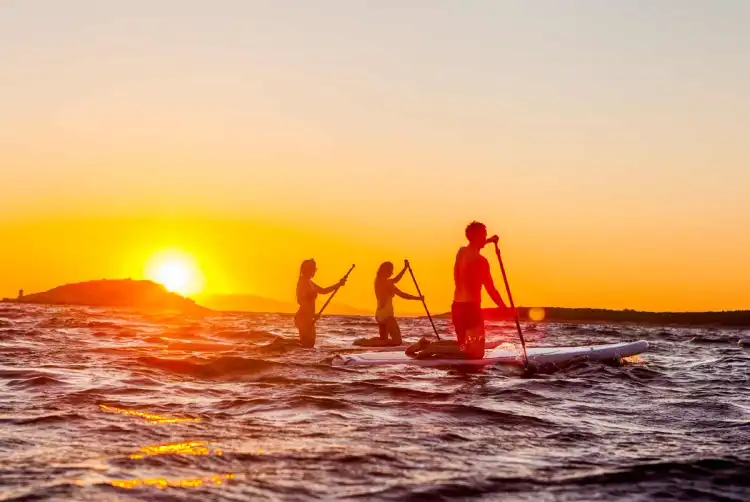 Group of people paddle-boarding at sunset in Croatia