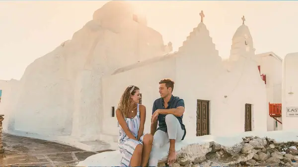 Couple sitting in front of white building in Ios