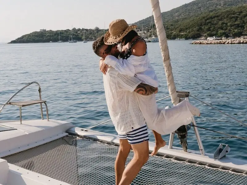 Couple embracing on the deck of a luxury catamaran in the Mediterranean Sea — capturing the romance and freedom of Yacht Getaways sailing holidays in Greece and Croatia.