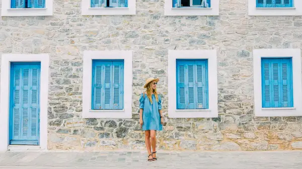 Woman standing in front of blue and white building