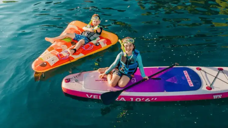 Two kids swimming and snorkelling around bright turquoise waters on a family cruise holiday in Croatia.