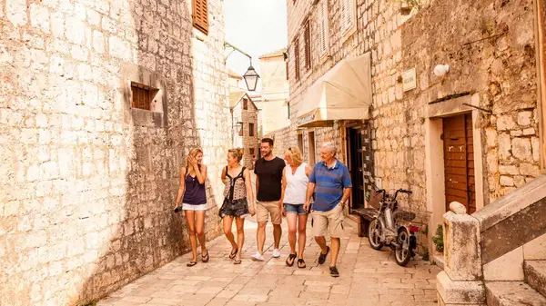 Group of people walk the streets of Stari Grad