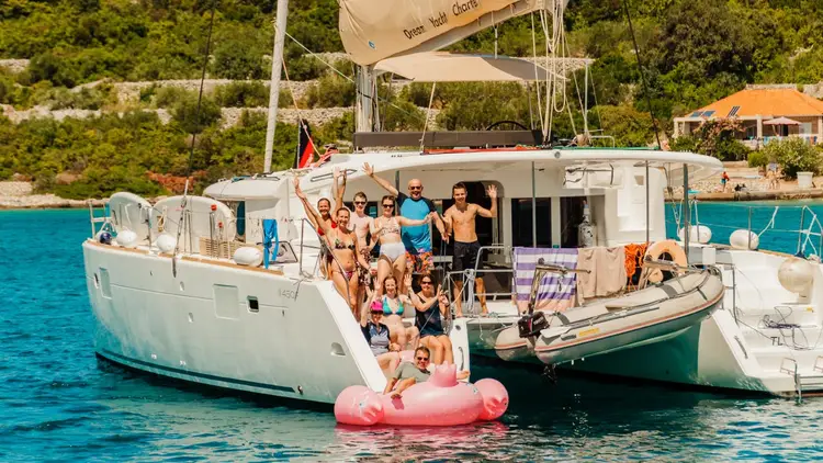 Group of people wave from a catamaran in Croatia