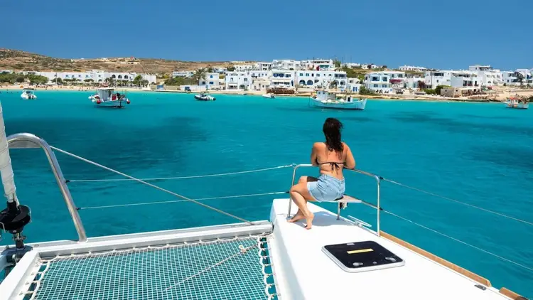 Photo of a woman sitting on a luxury catamaran in Greece on a Greek island cruise.