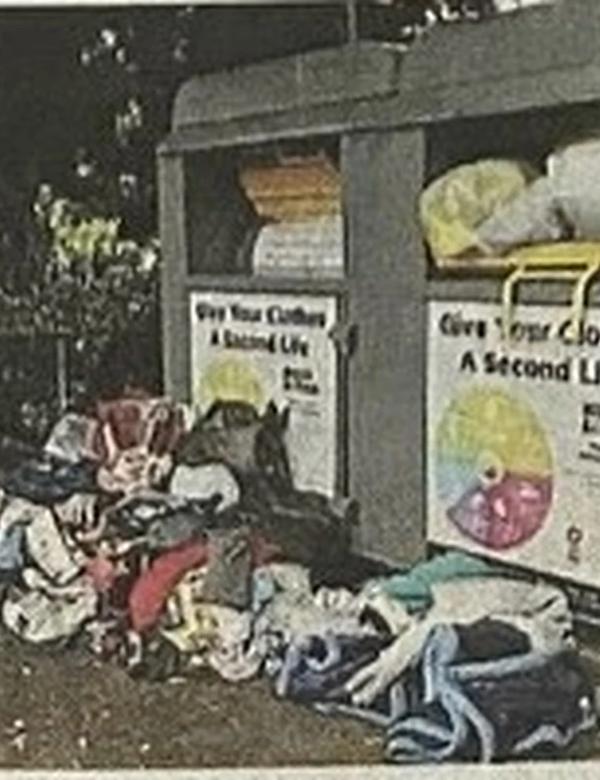 Clothing and household goods dumped beside overflowing charity donation bins