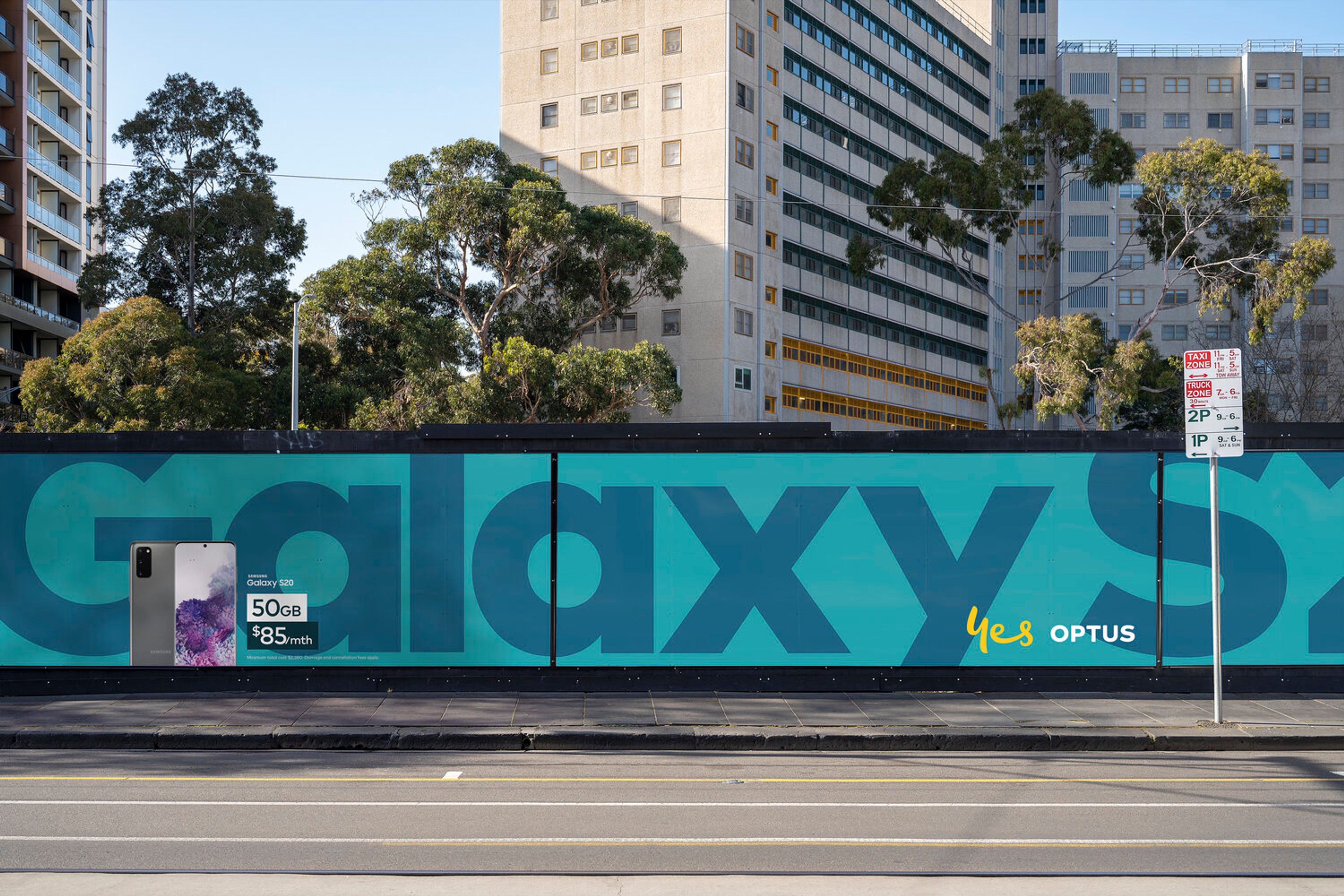 Teal construction hoarding running a giant 'Galaxy' wordmark beside the Optus lock-up