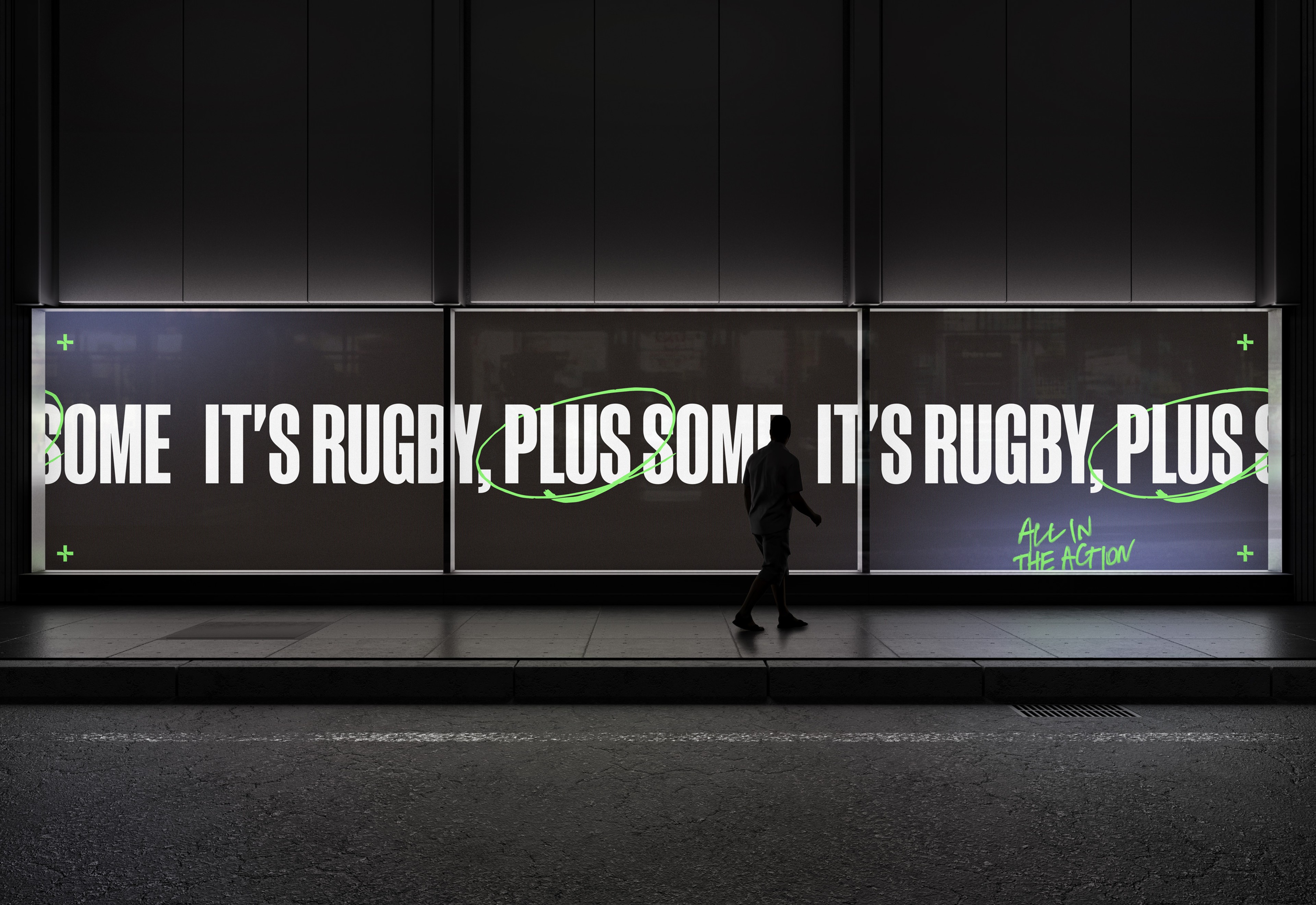 Backlit street billboards reading 'It's rugby, plus some' with a looping green scrawl at night