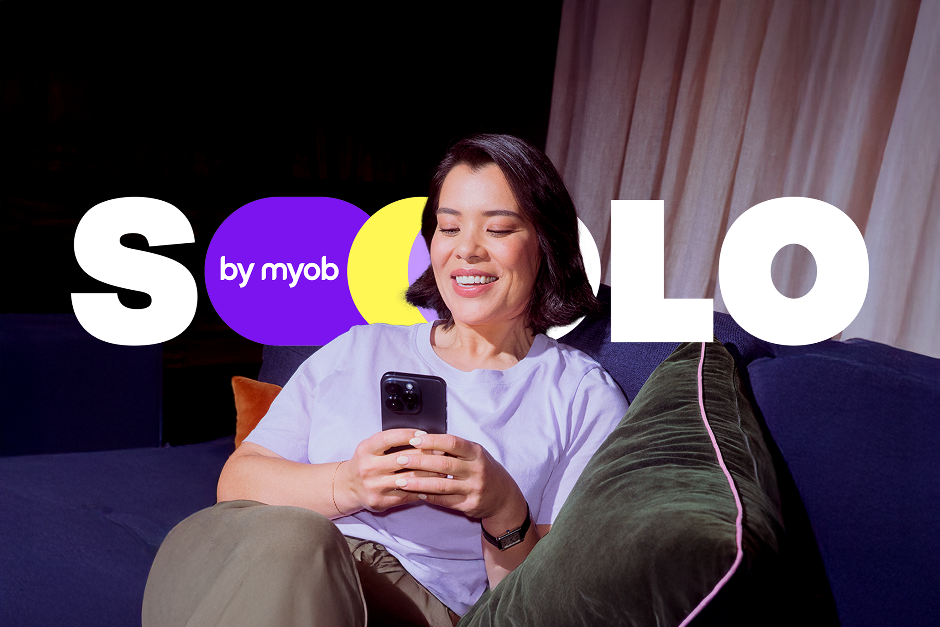 Solo by MYOB brand identity: bold dotted wordmark over a smiling sole operator using the app at home