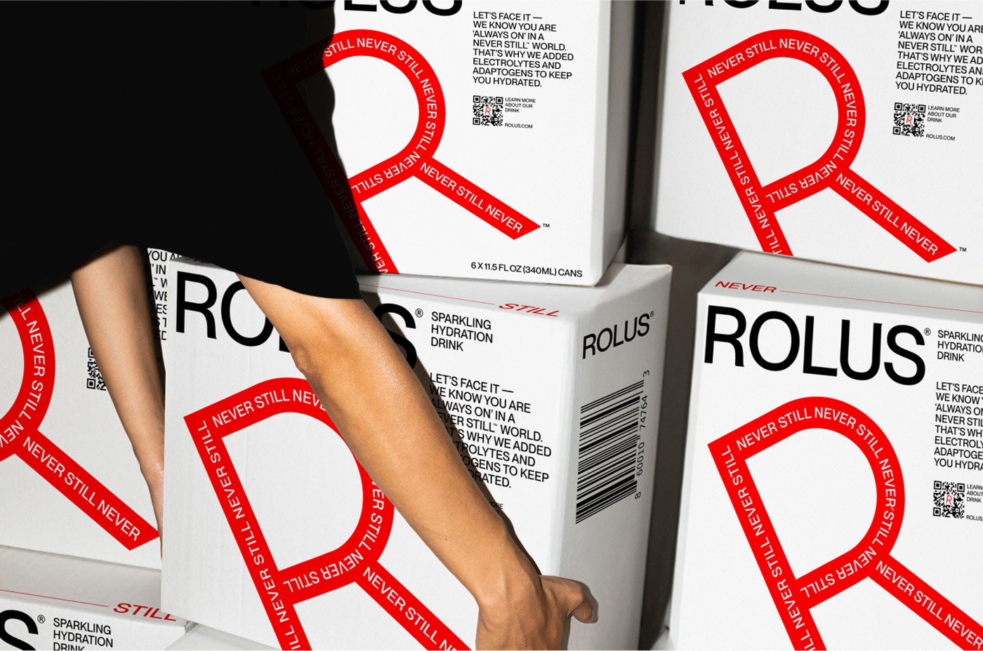 Stacked shipping cartons carrying an oversized red R and Never Still type, one being lifted