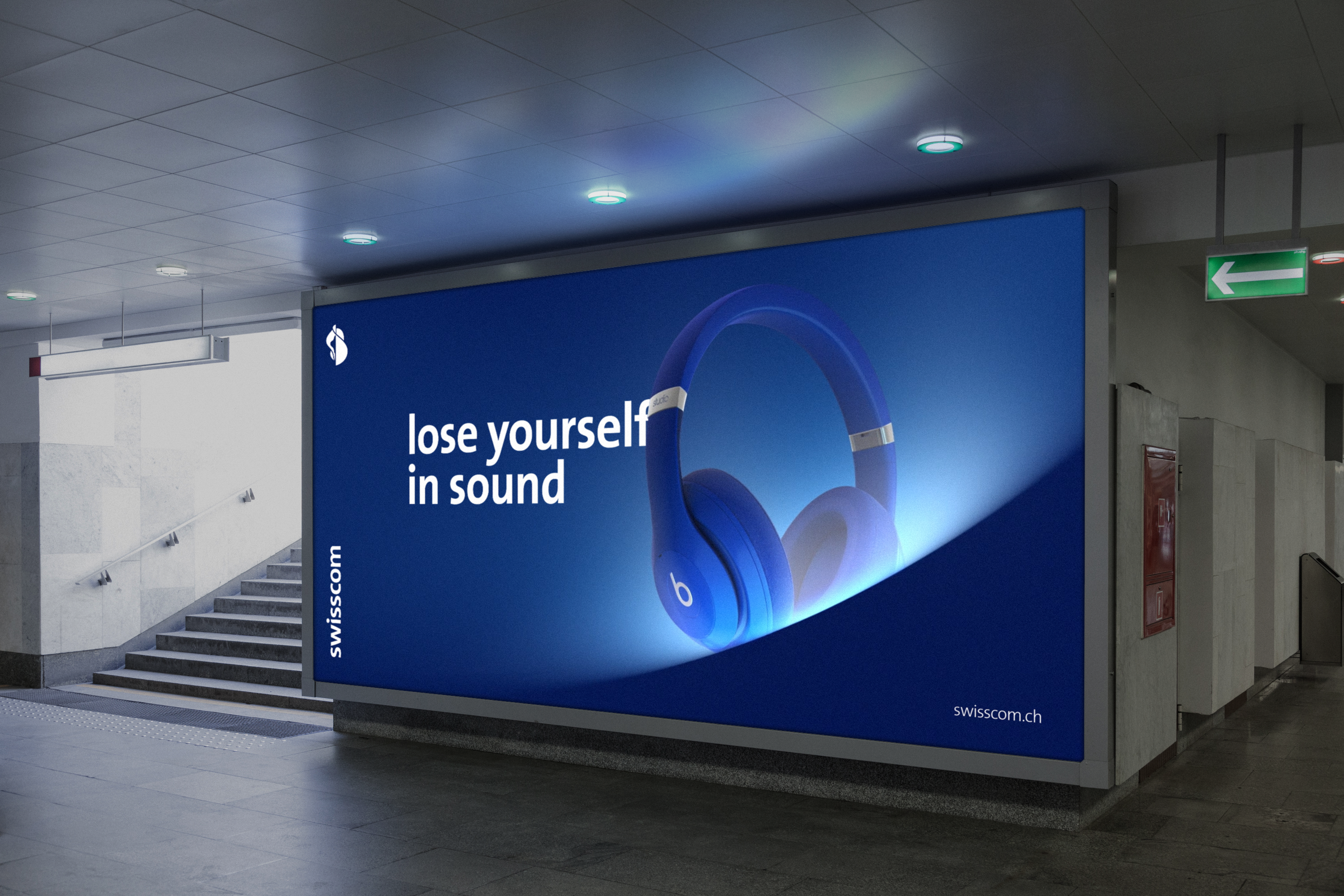 Illuminated wide-format ad panel in an underground walkway, deep blue artwork with over-ear headphones