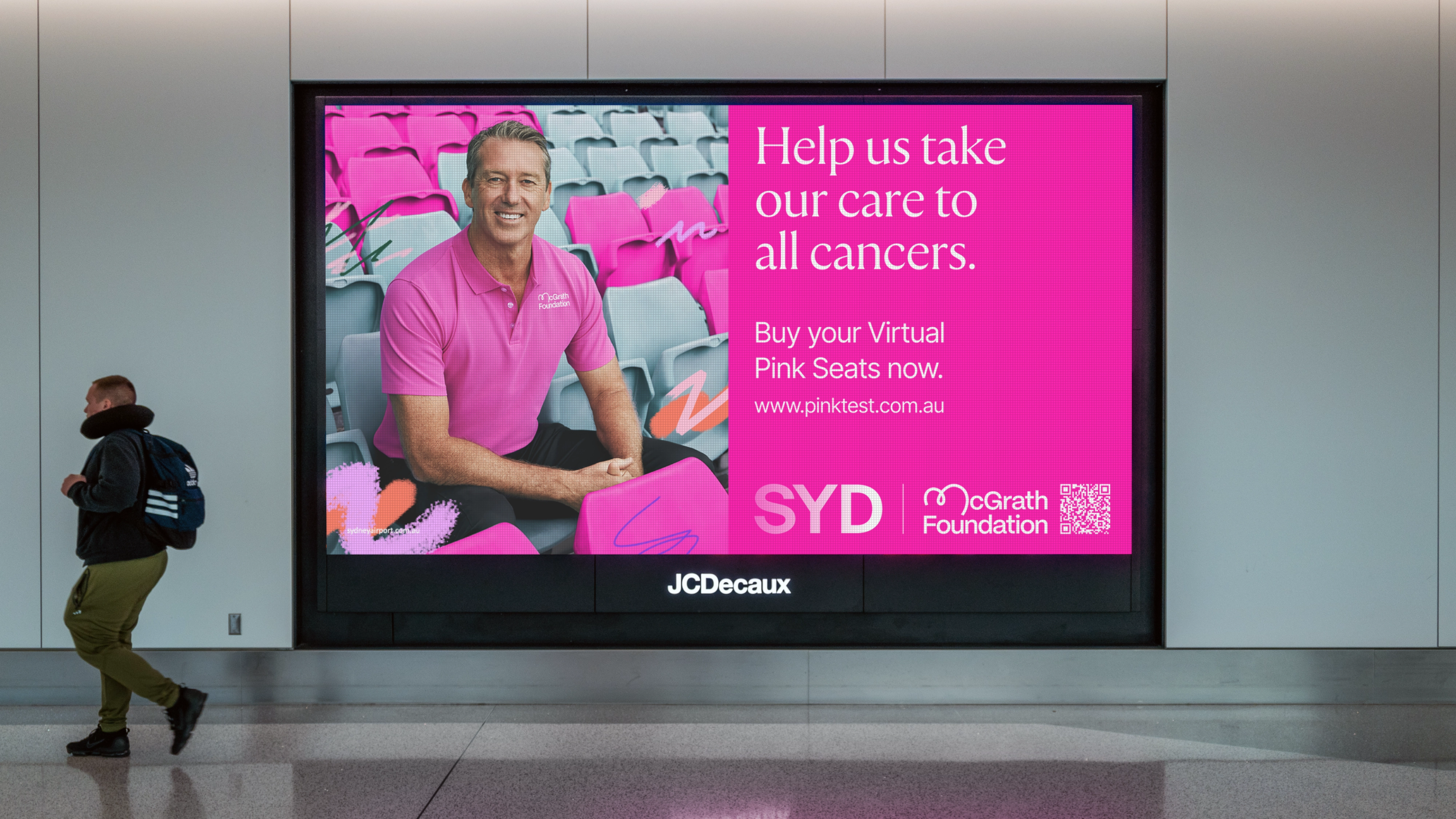 Airport digital screen in magenta promoting Virtual Pink Seats for the Sydney Pink Test