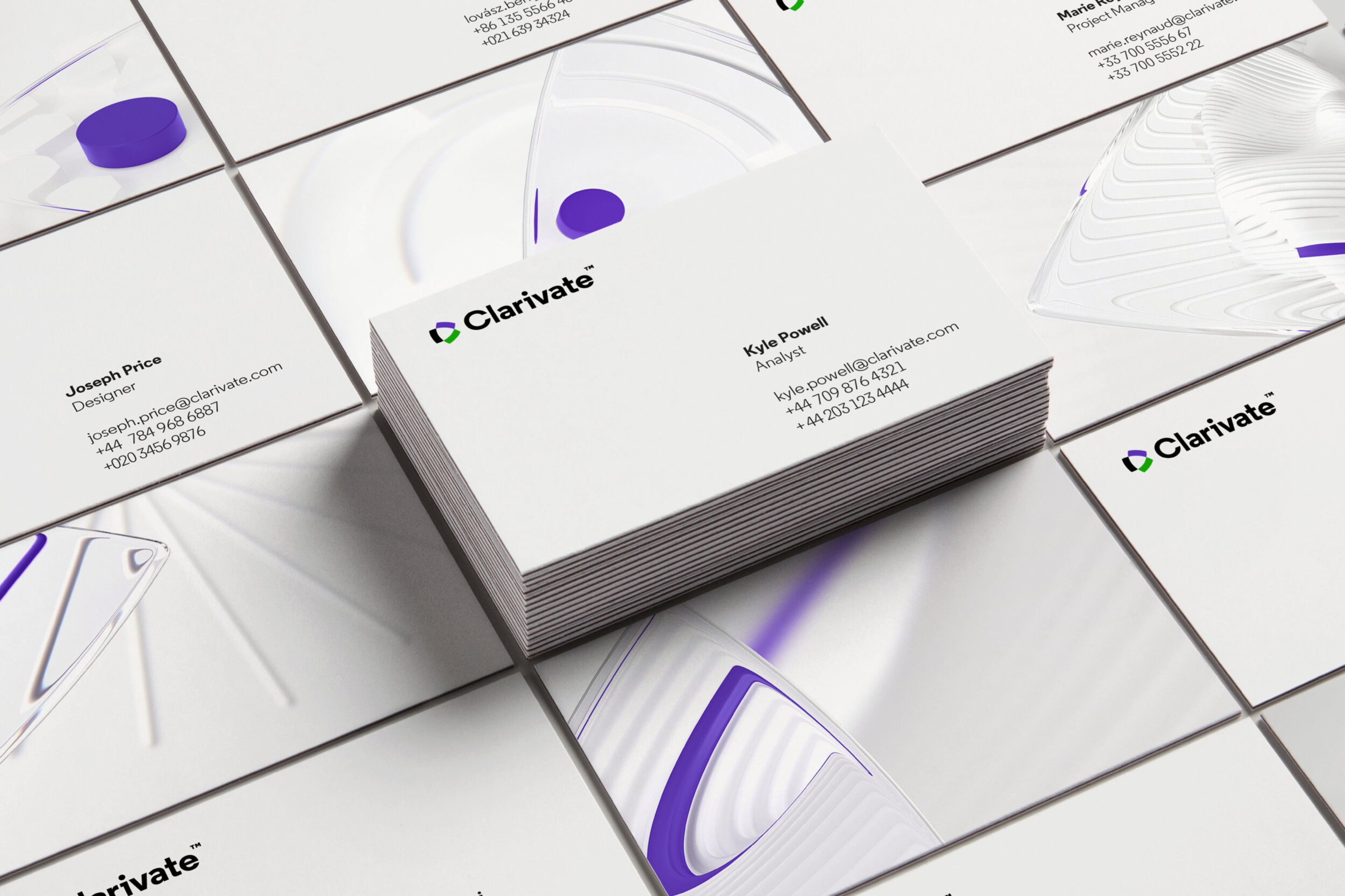 Clarivate business cards stacked over a grid of cards printed with white and violet lens renders