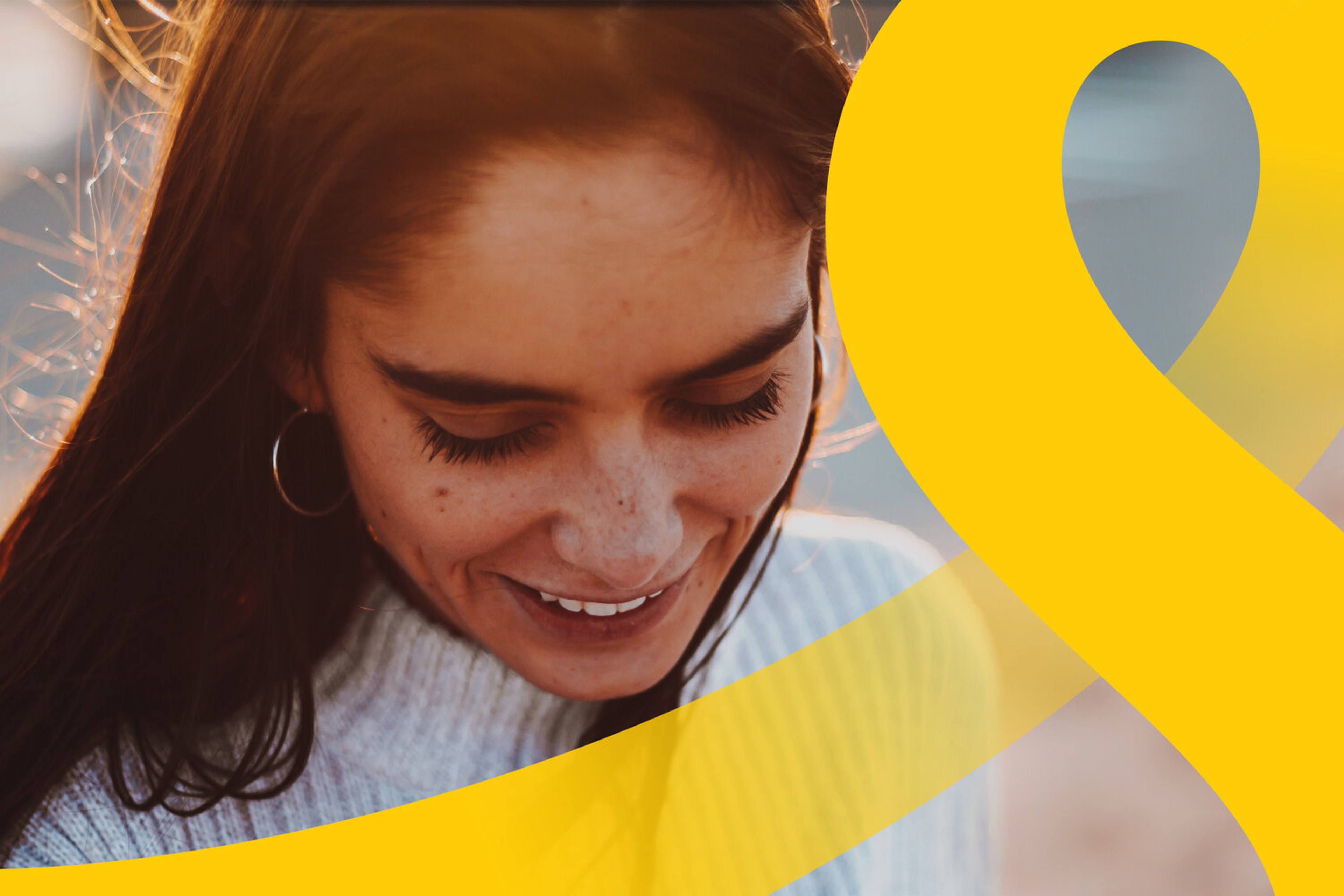 Brand image cropping an oversized yellow letterform across a smiling portrait in warm light