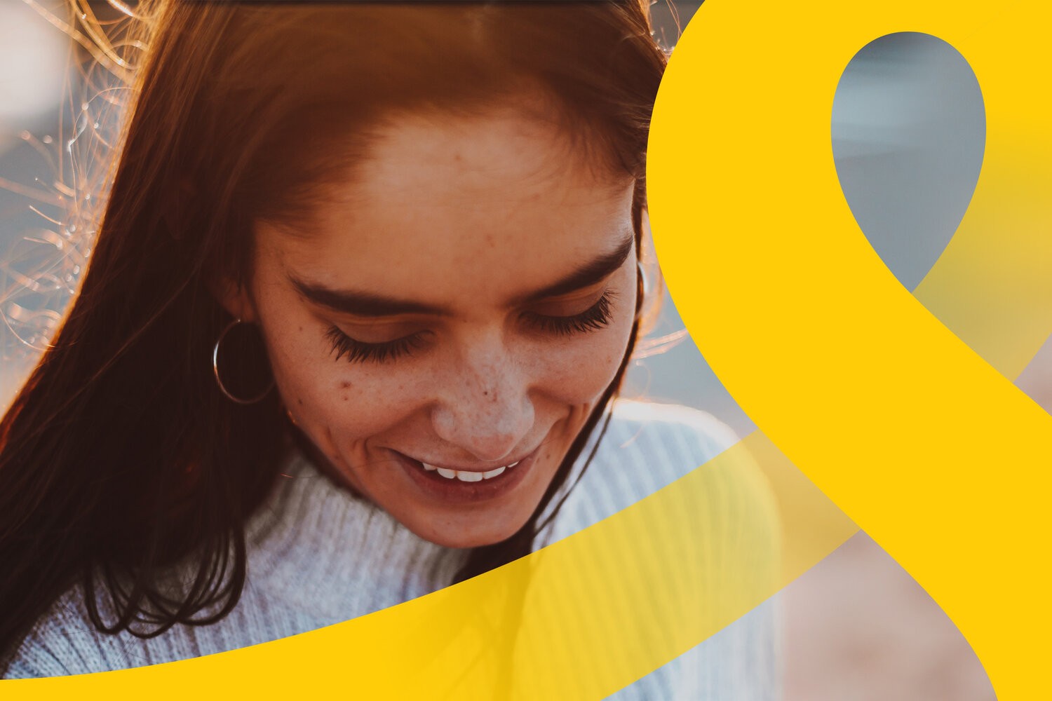 Brand image cropping an oversized yellow letterform across a smiling portrait in warm light