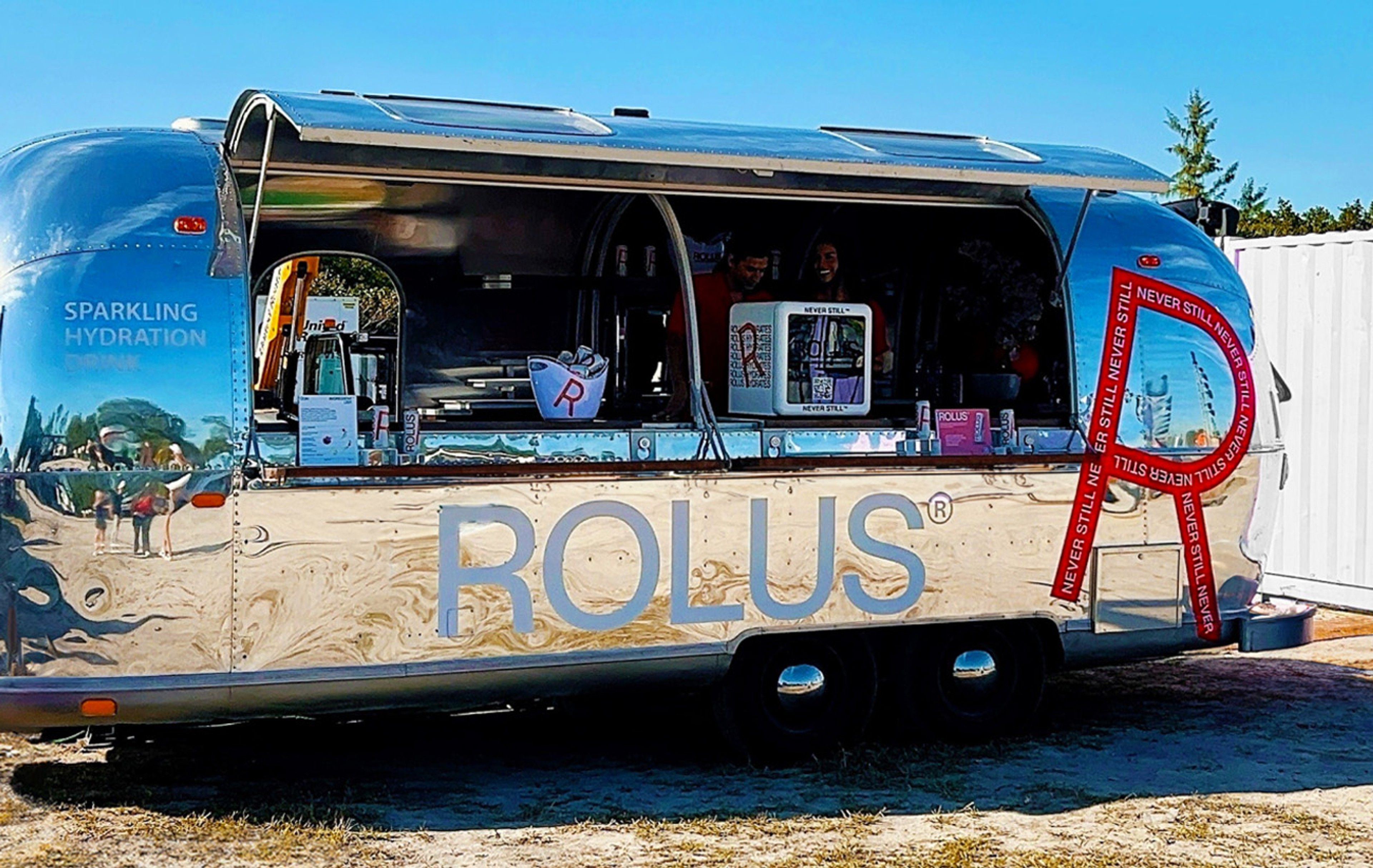 Mirrored Airstream trailer wrapped as a Rolus sampling bar with a red Never Still ribbon