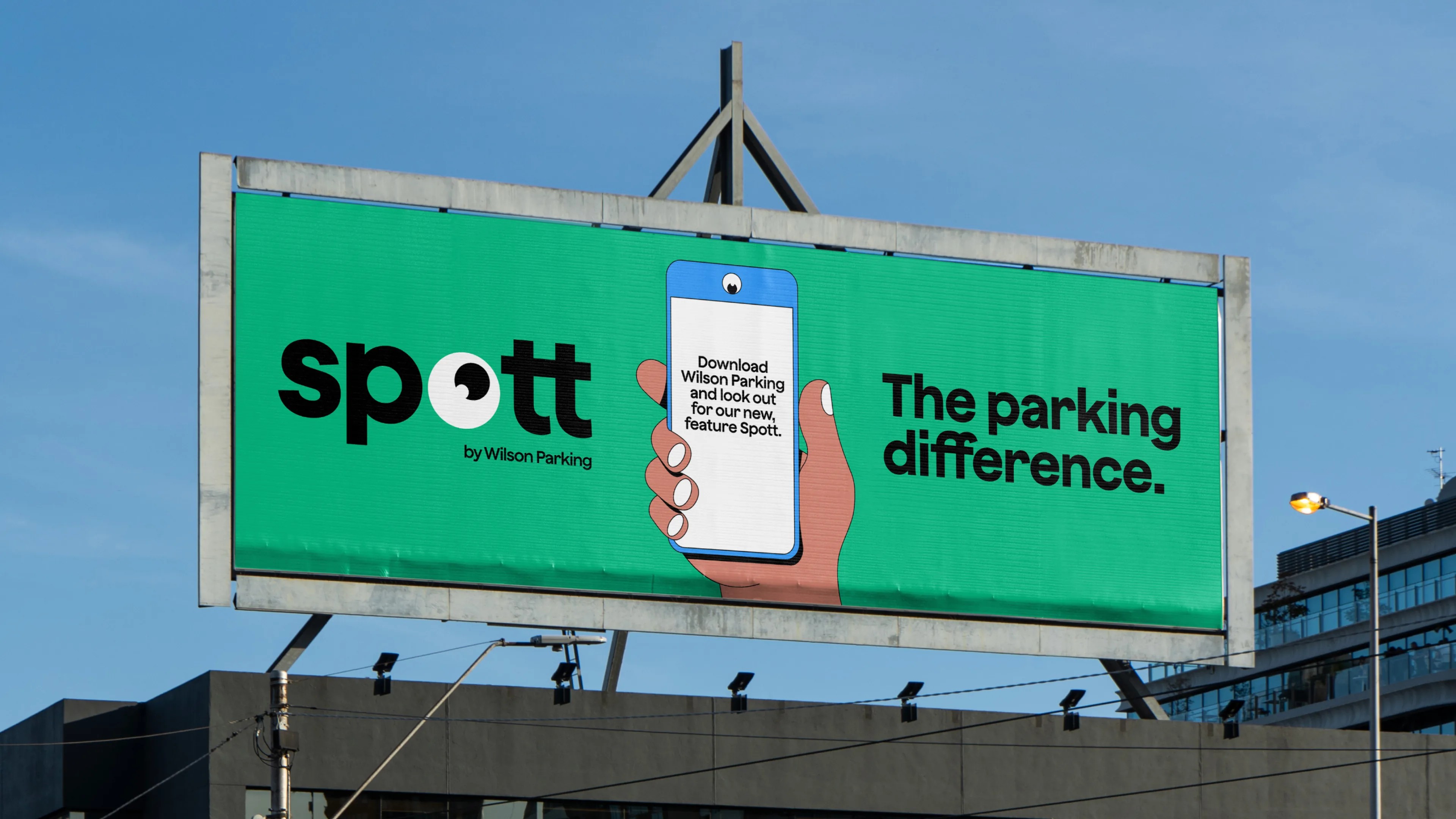 Roadside billboard with the Spott logo, an illustrated hand holding a phone, and 'The parking difference'