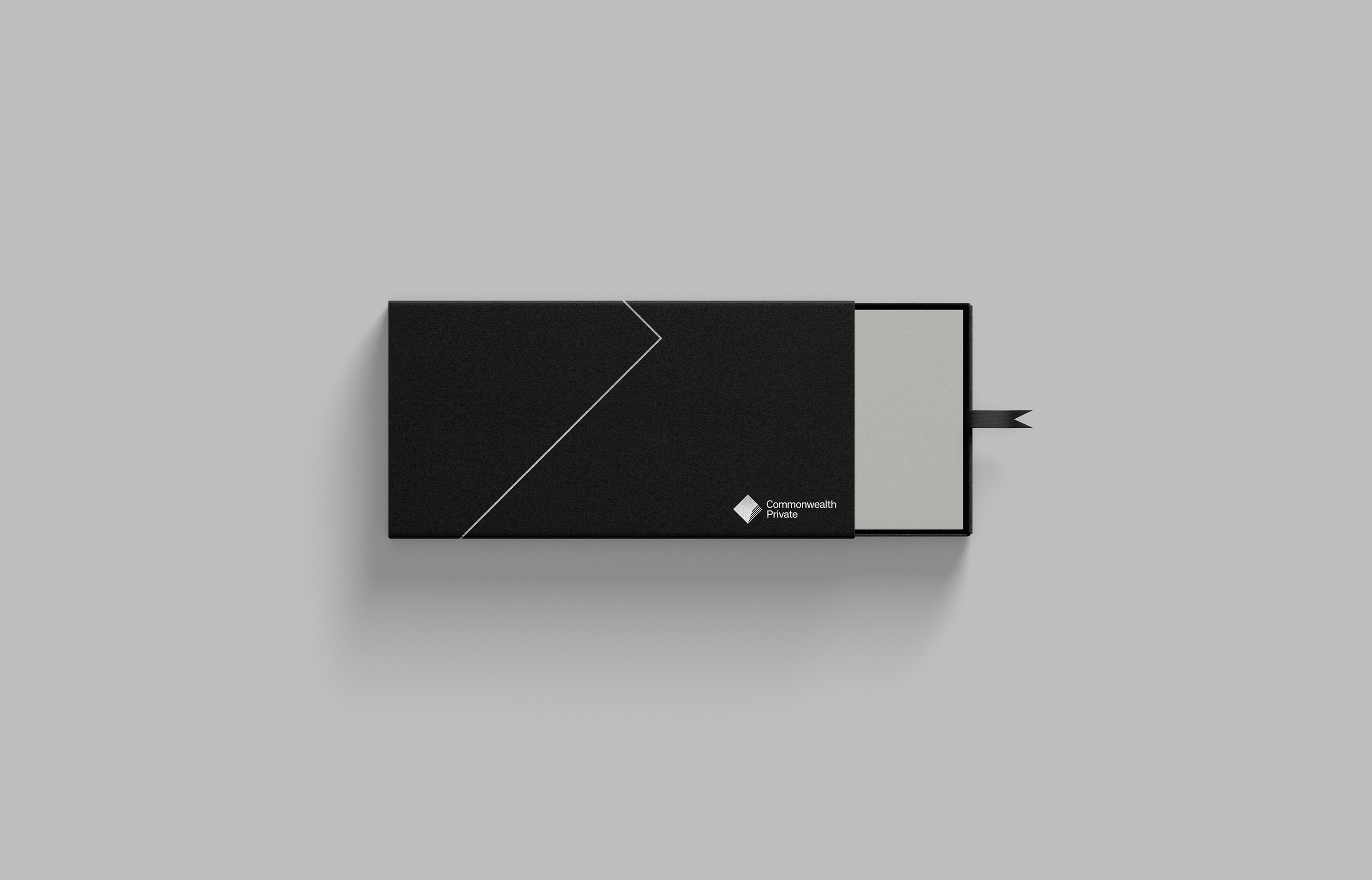 Black slipcase box with a silver chevron rule and the Commonwealth Private diamond mark
