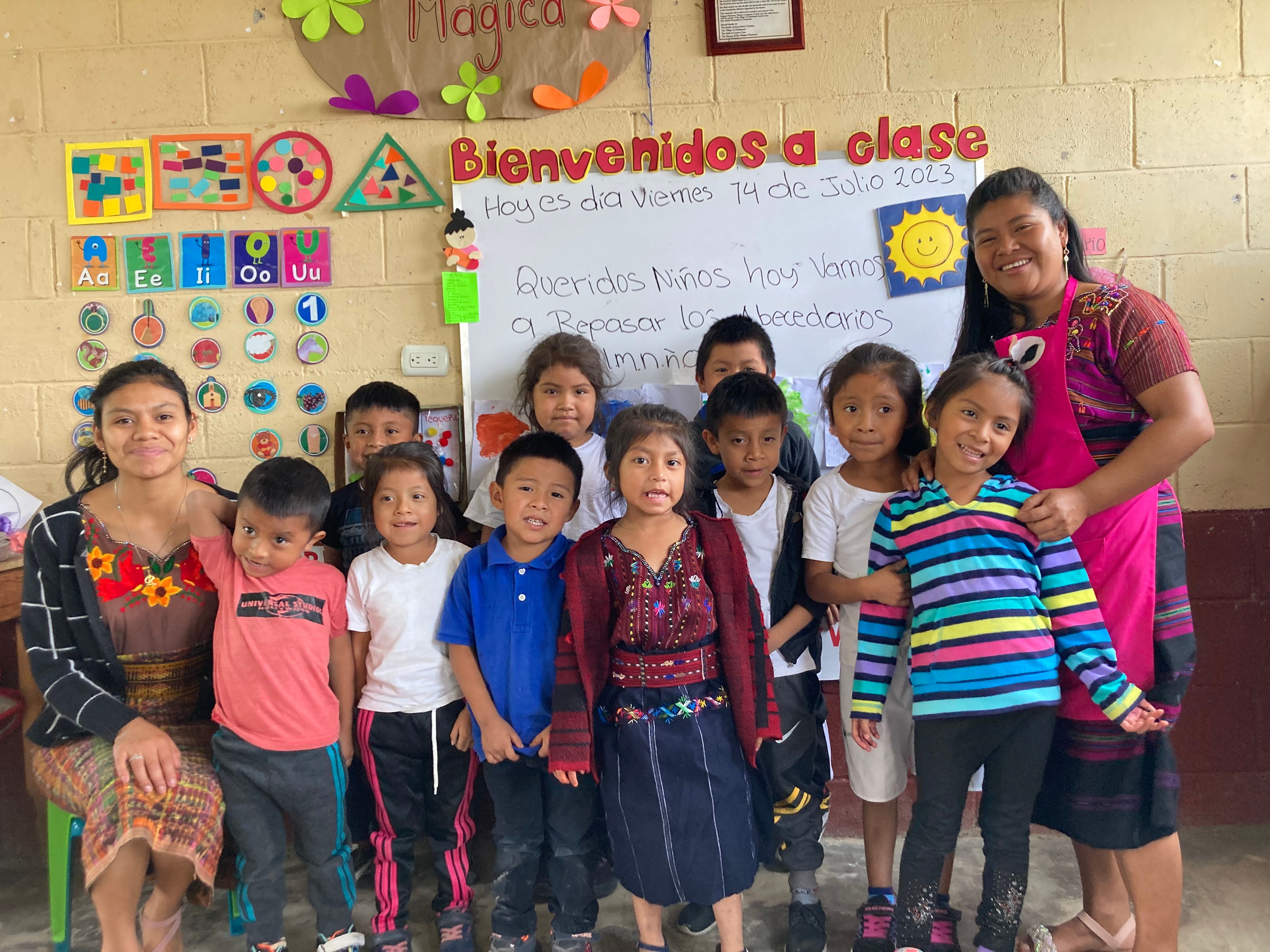A teacher with young students in a rural Guatemalan classroom