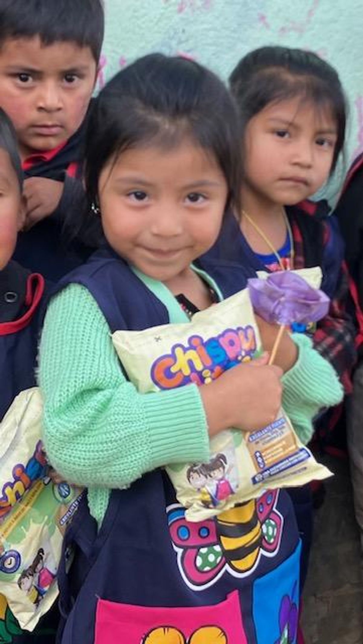 A young girl in rural Guatemala holding Chispuditos supplement.