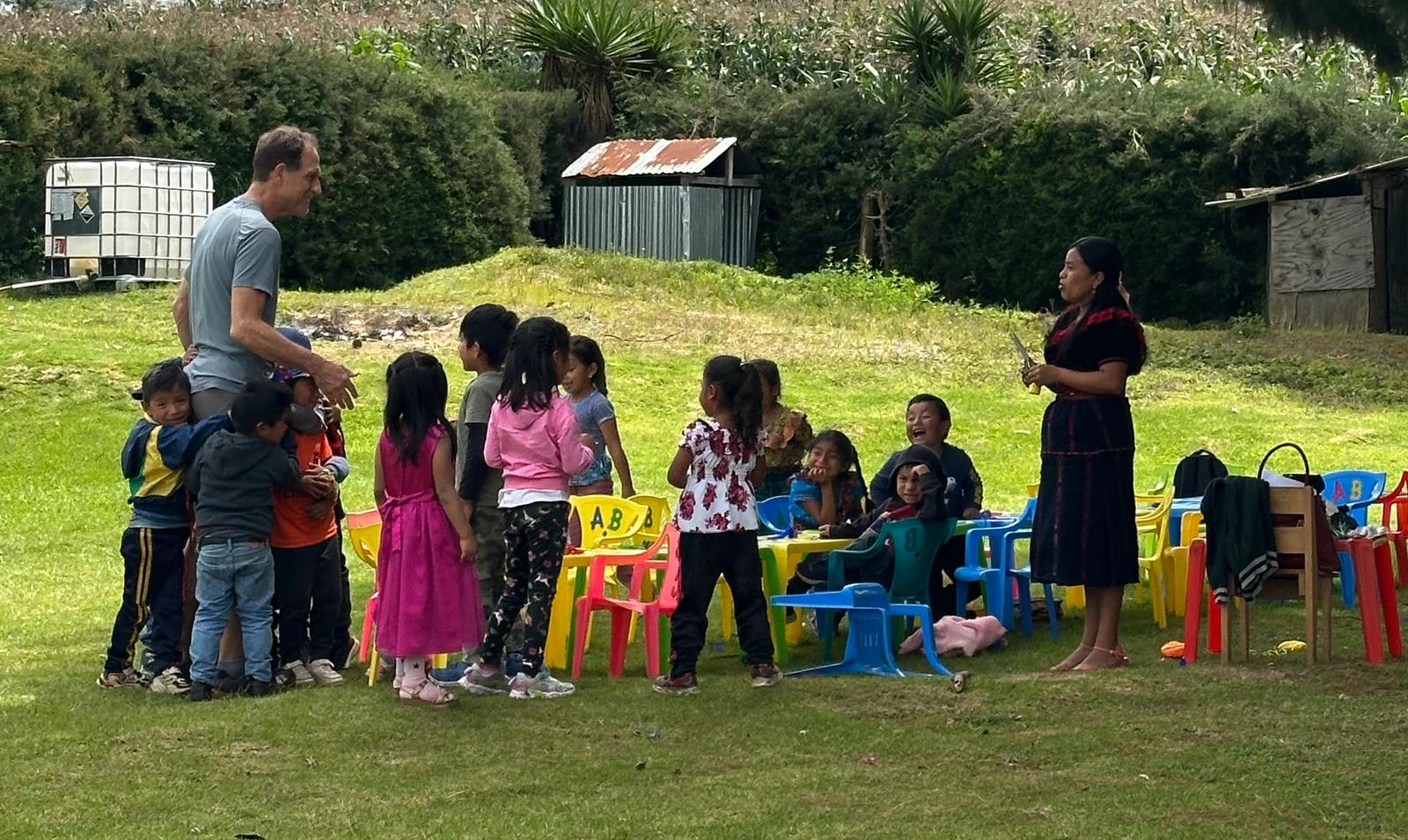 An open-air classroom in rural Guatemala, a facilitator teaching at the board
