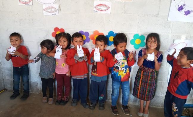 An open-air classroom in rural Guatemala, a facilitator teaching at the board