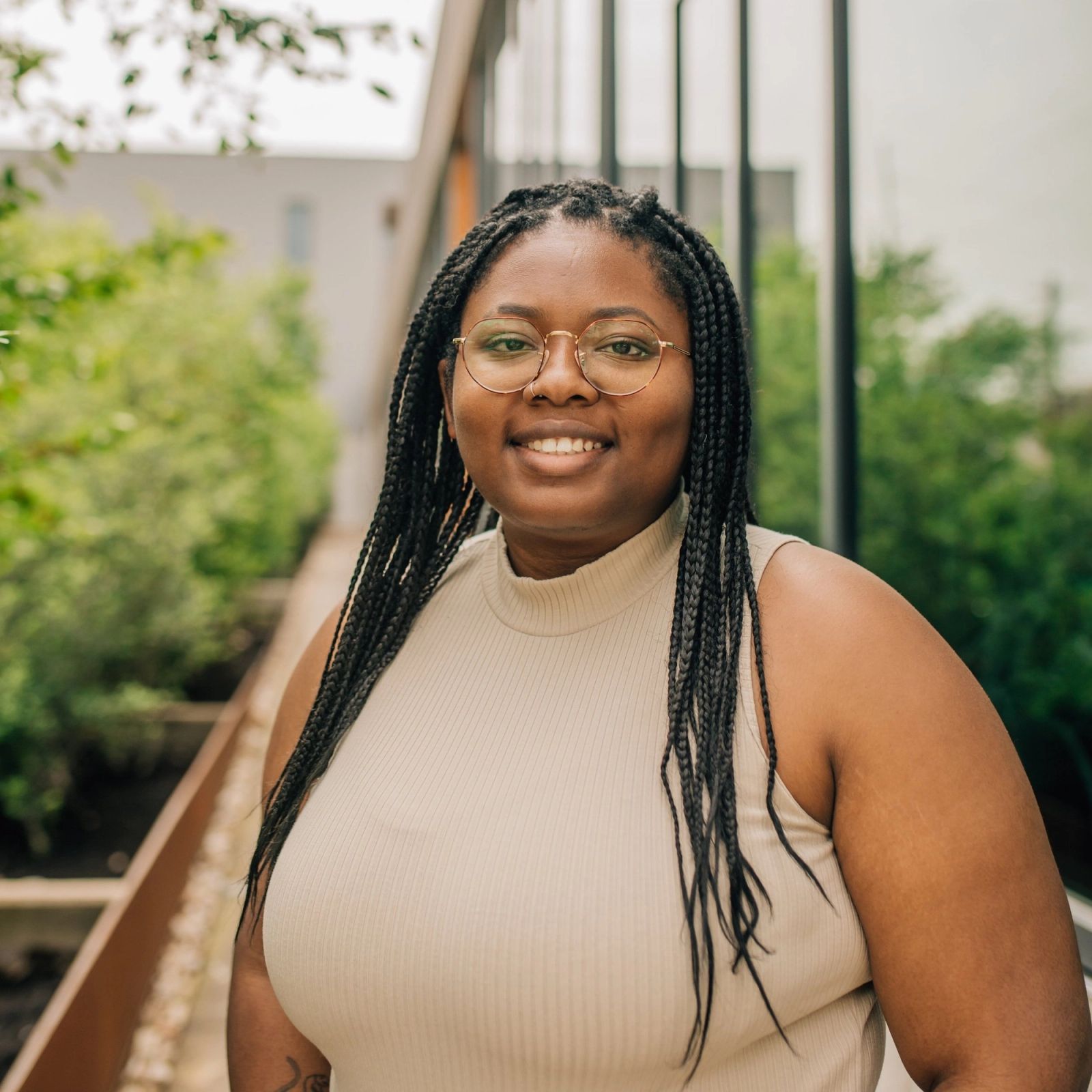 Narsis wearing glasses and a tank top is smiling for the camera .