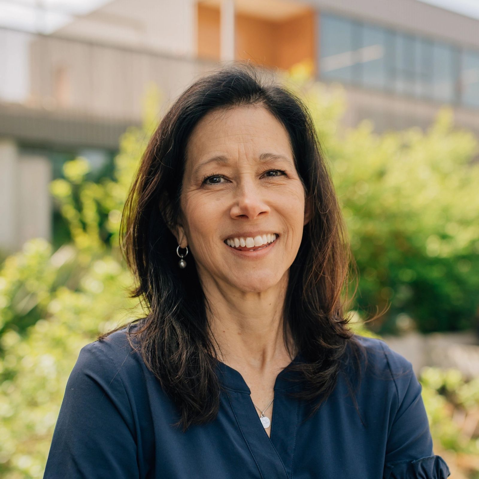 Valerie in a blue shirt is smiling for the camera .