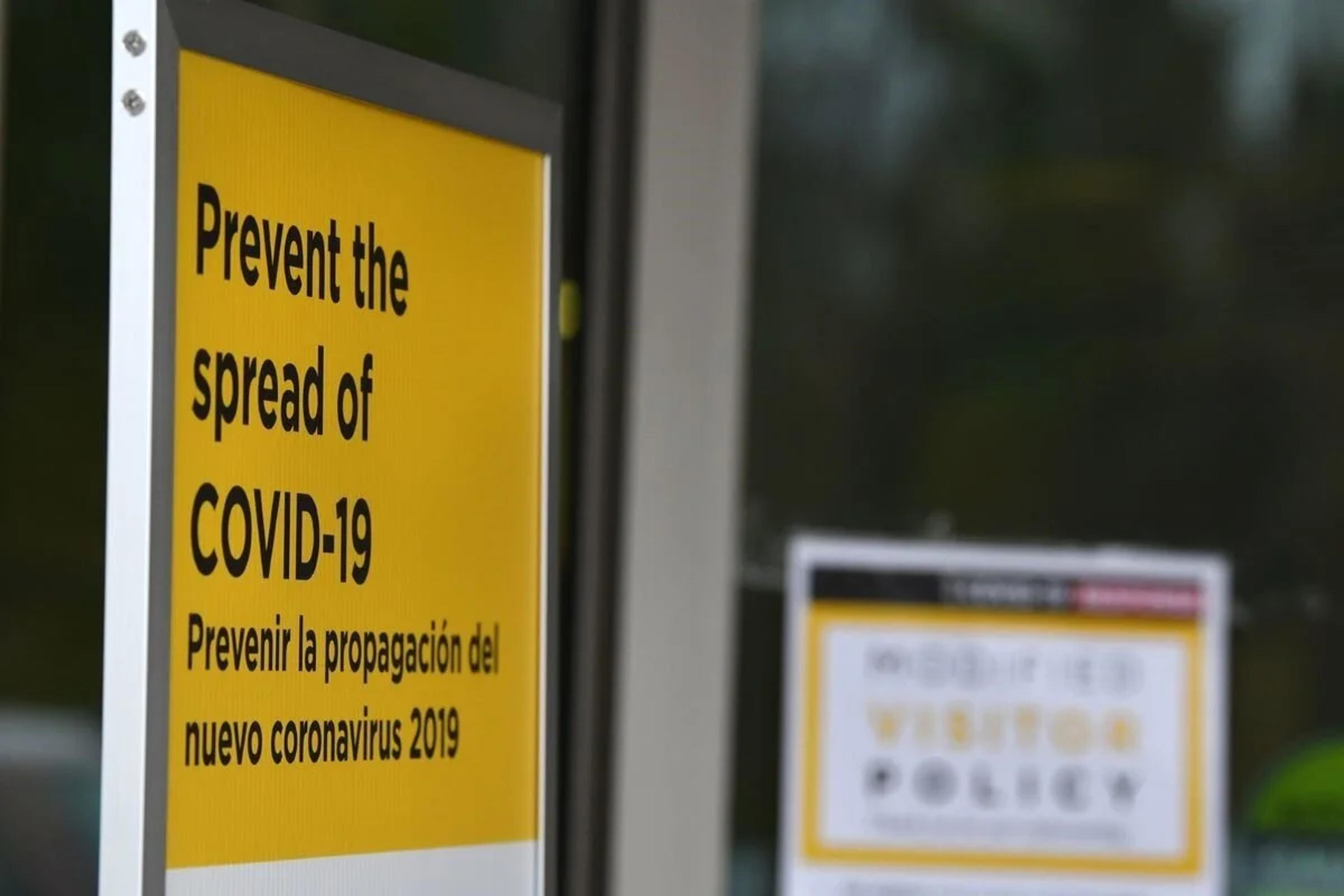 sign on door regarding covid-19 prevention