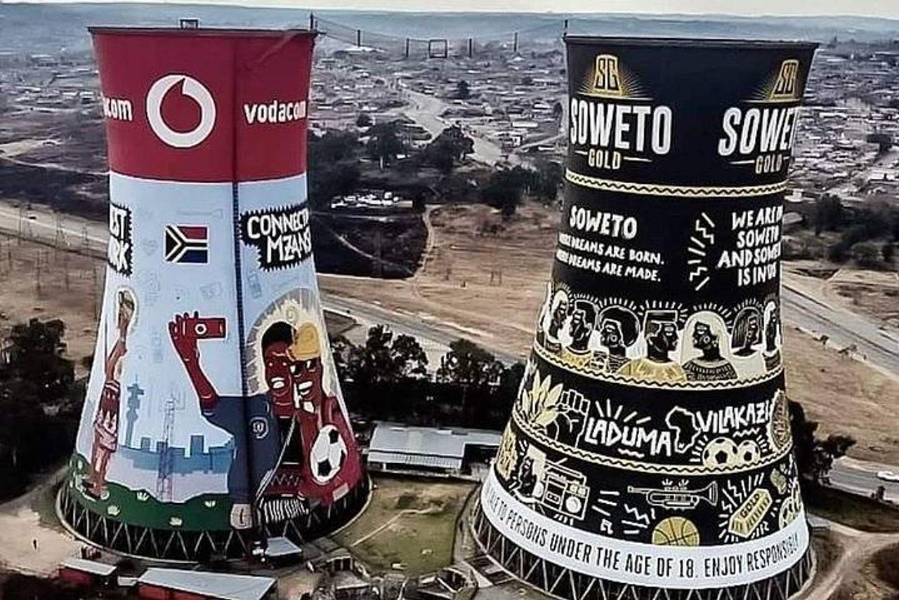 The painted Orlando Towers, two former power station cooling towers in Soweto, with houses stretching out behind them