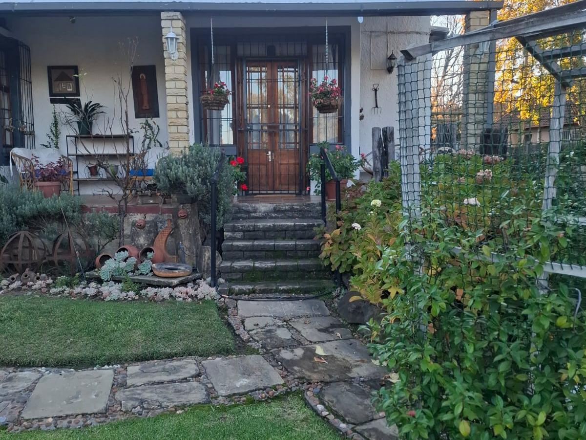 Stone path and steps leading through a leafy garden to the front stoep of a cottage at 33 Loop Street in Ladybrand