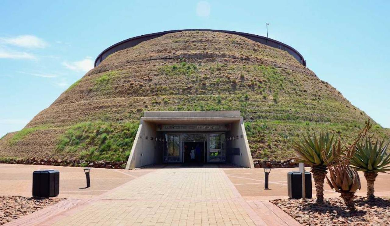 The grass-covered Maropeng visitor centre at the Cradle of Humankind, with aloes beside the entrance path