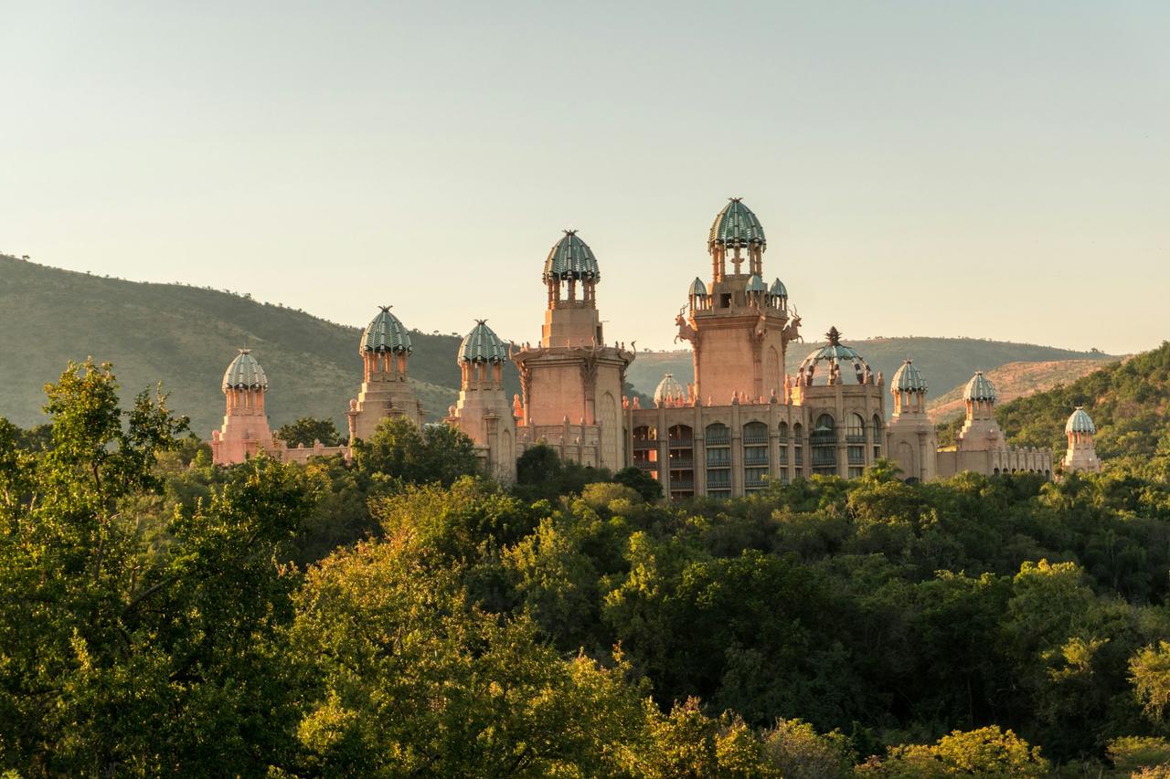 The Palace of the Lost City at Sun City, with domed towers above green bushveld and hills