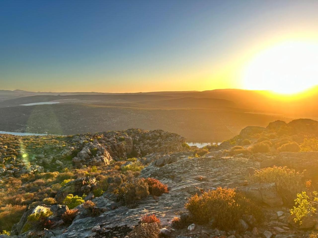 Sunset over a rocky fynbos ridge at Nardouw near Clanwilliam, with water visible in the valley below
