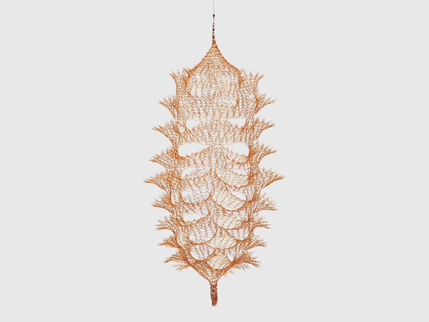 A hanging copper wire sculpture by Ruth Asawa, titled Untitled (S.524, Hanging Miniature Single Section, Reversible Six Columns of Open Windows), circa 1980-1989.