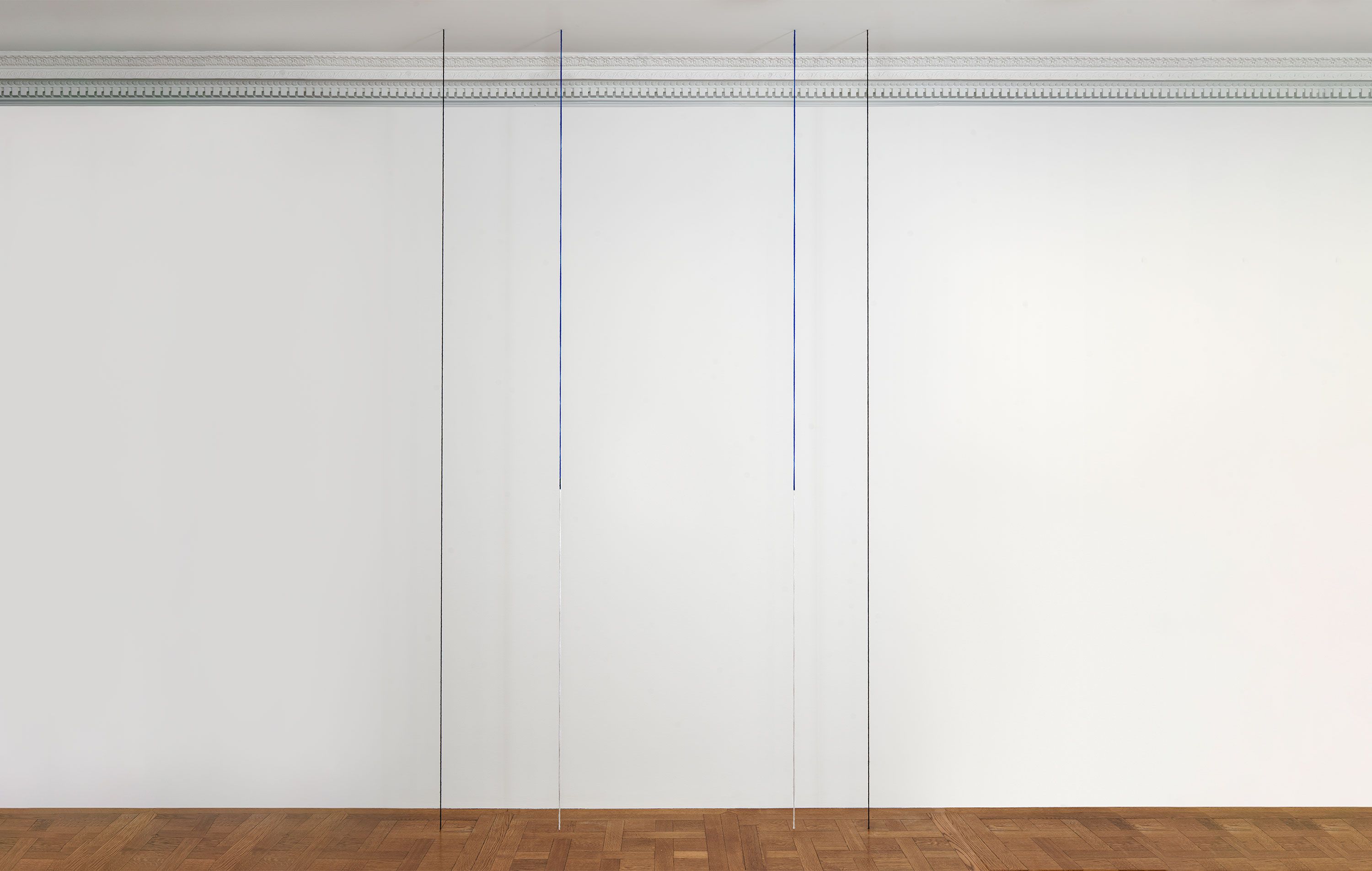 A black, blue, and white acrylic yarn artwork by Fred Sandback, titled Untitled (Sculptural Study, Four-part Vertical Construction), circa 1987 and 2020.