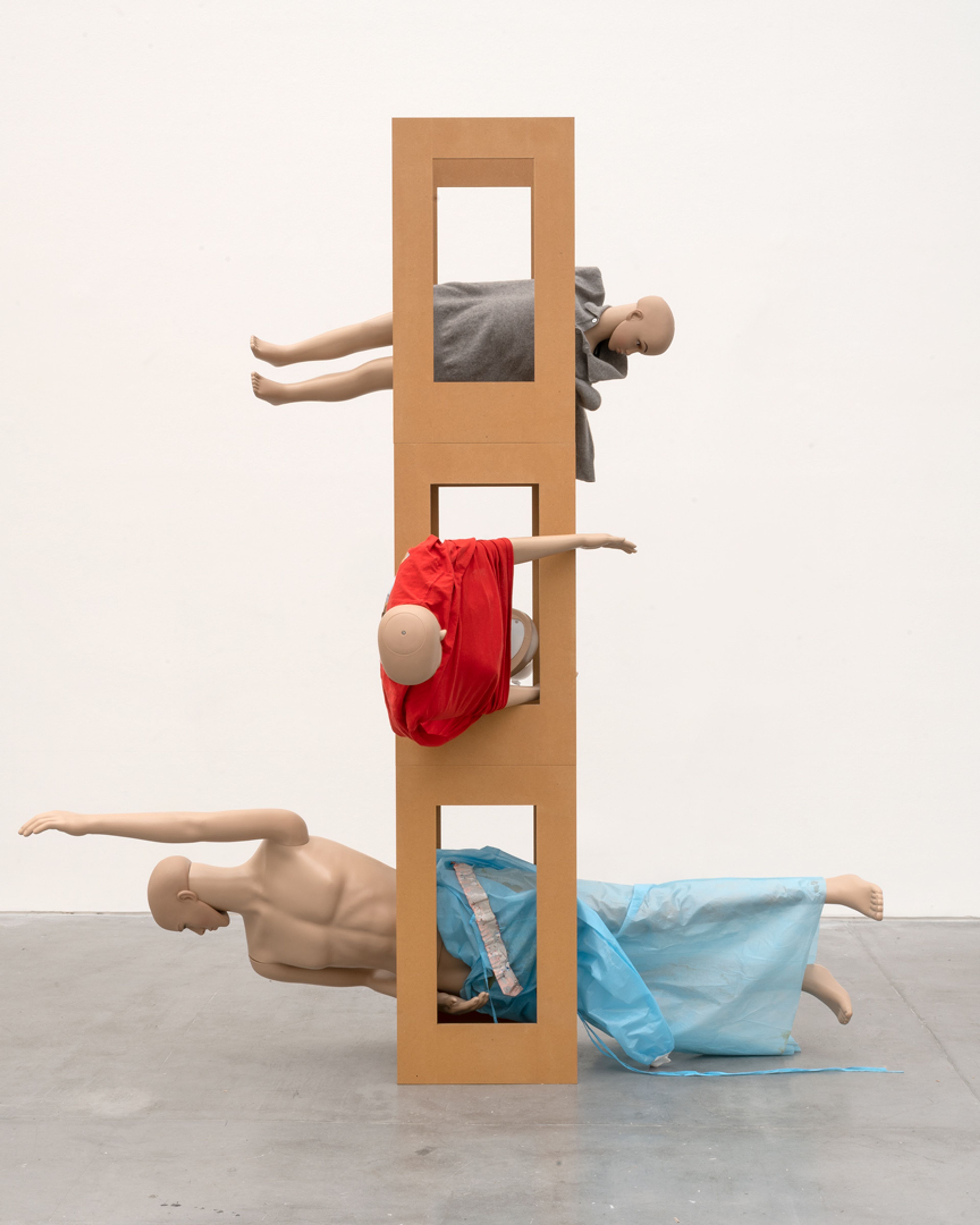 An untitled MDF tower, mannequins, leather, plastic tape, hospital gown, jumper with transfer print, and jumper sculpture by Isa Genzken, dated 2018.