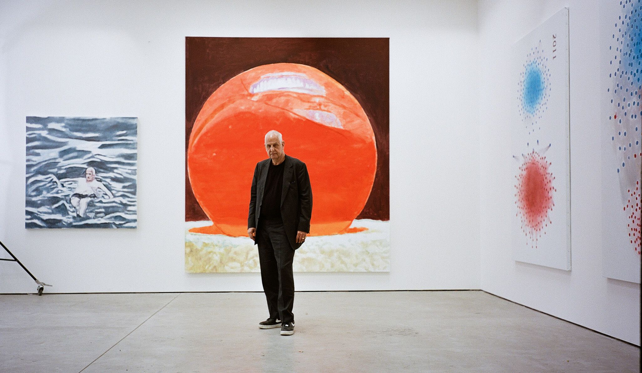 An image of the artist in front of his painting Eternity, dated 2021