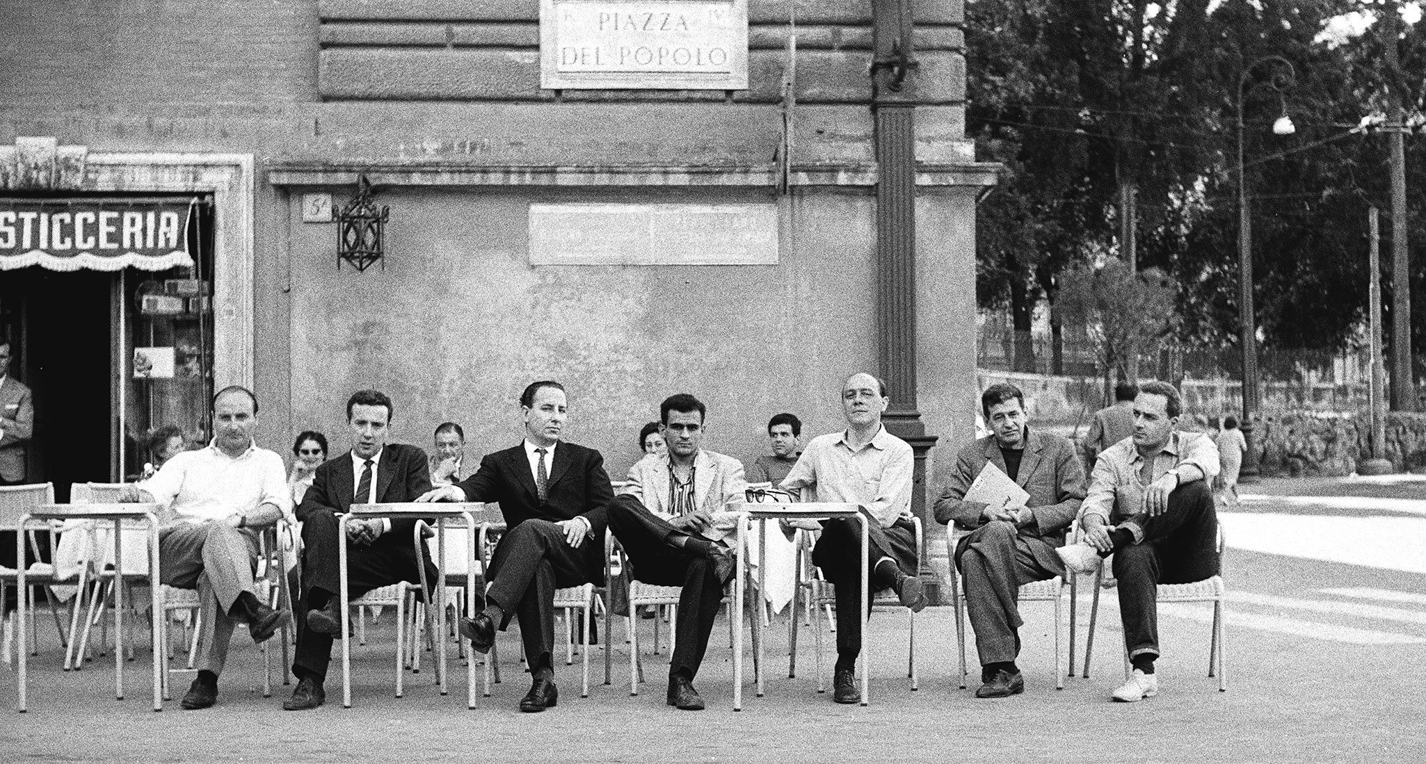 A photo of members of the “Crack” artist group at Caffè Rosati in Piazza del Popolo, Rome, 1960; from left to right: Mimmo Rotella, Achille Perilli, Fabio Mauri, Gino Marotta, Piero Dorazio, Giulio Turcato, and Gastone Novelli; photographed by Dortch while on assignment for the magazine Metro and published in Metro no. 1, 1960.
