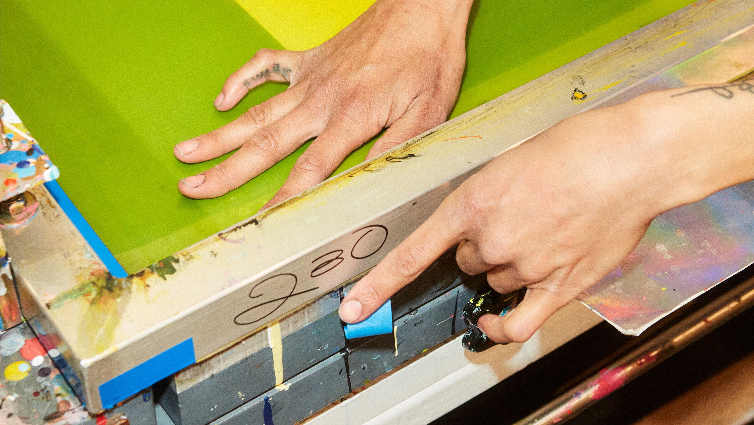 A photograph of Diuguid setting up her screenprinting press by Rafael Rios, dated 2022.