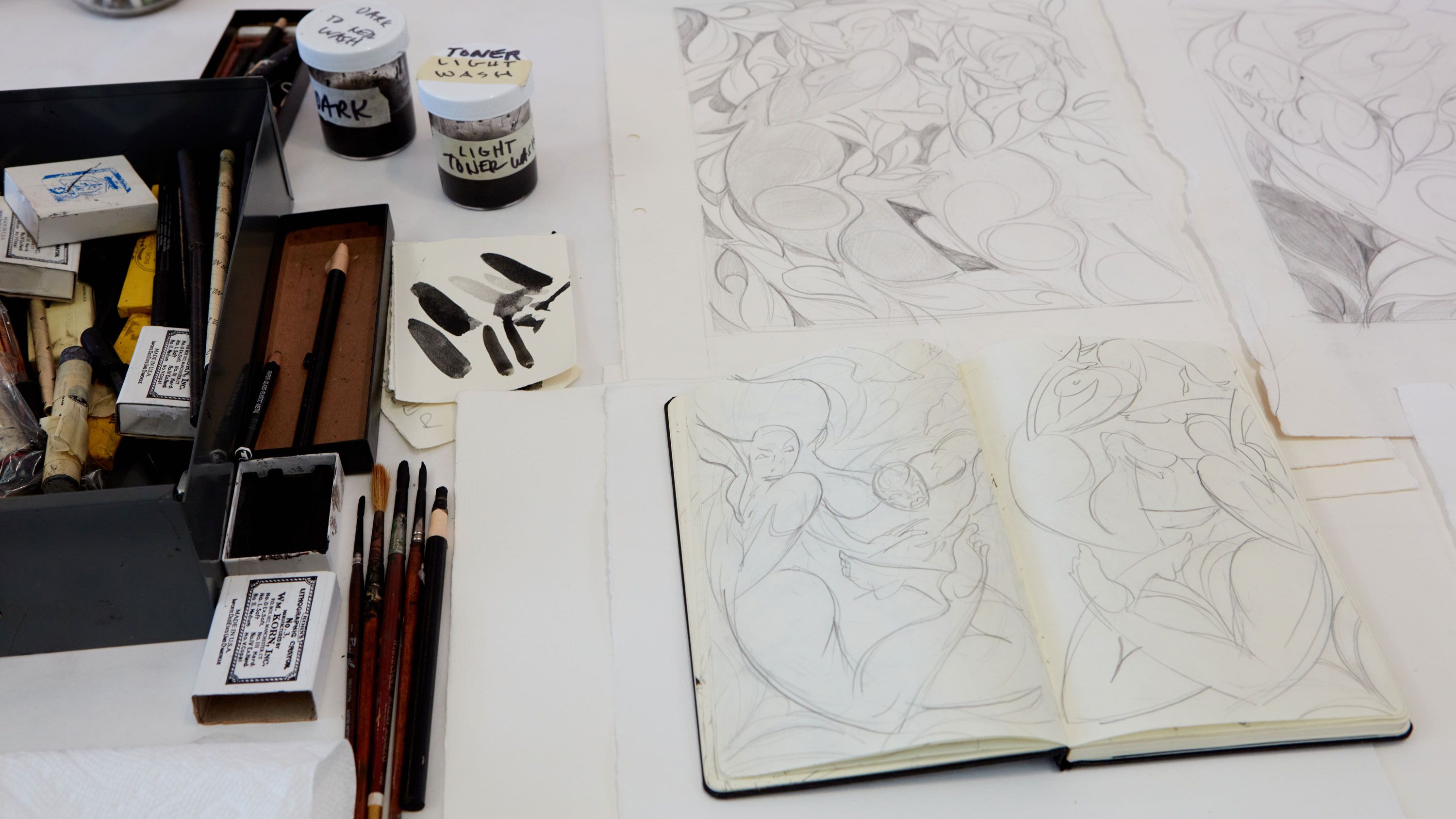 This photograph features the artist exploring his imagery through studies in ink pen on paper, seen here at his workspace at Jungle Press Editions print shop. Photo by Rafael Rios