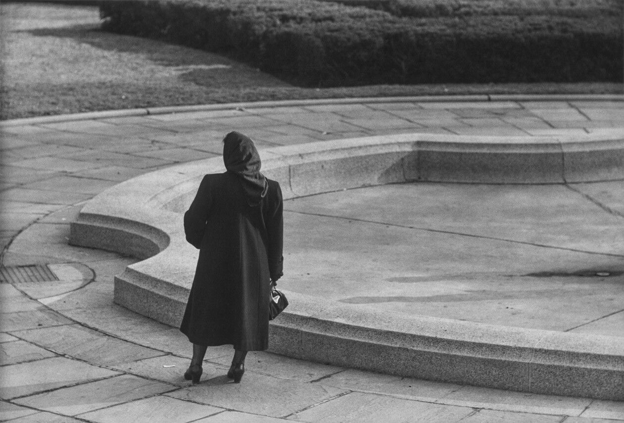 A silver gelatin print by Roy DeCarava, titled Woman at fountain, dated 1964.