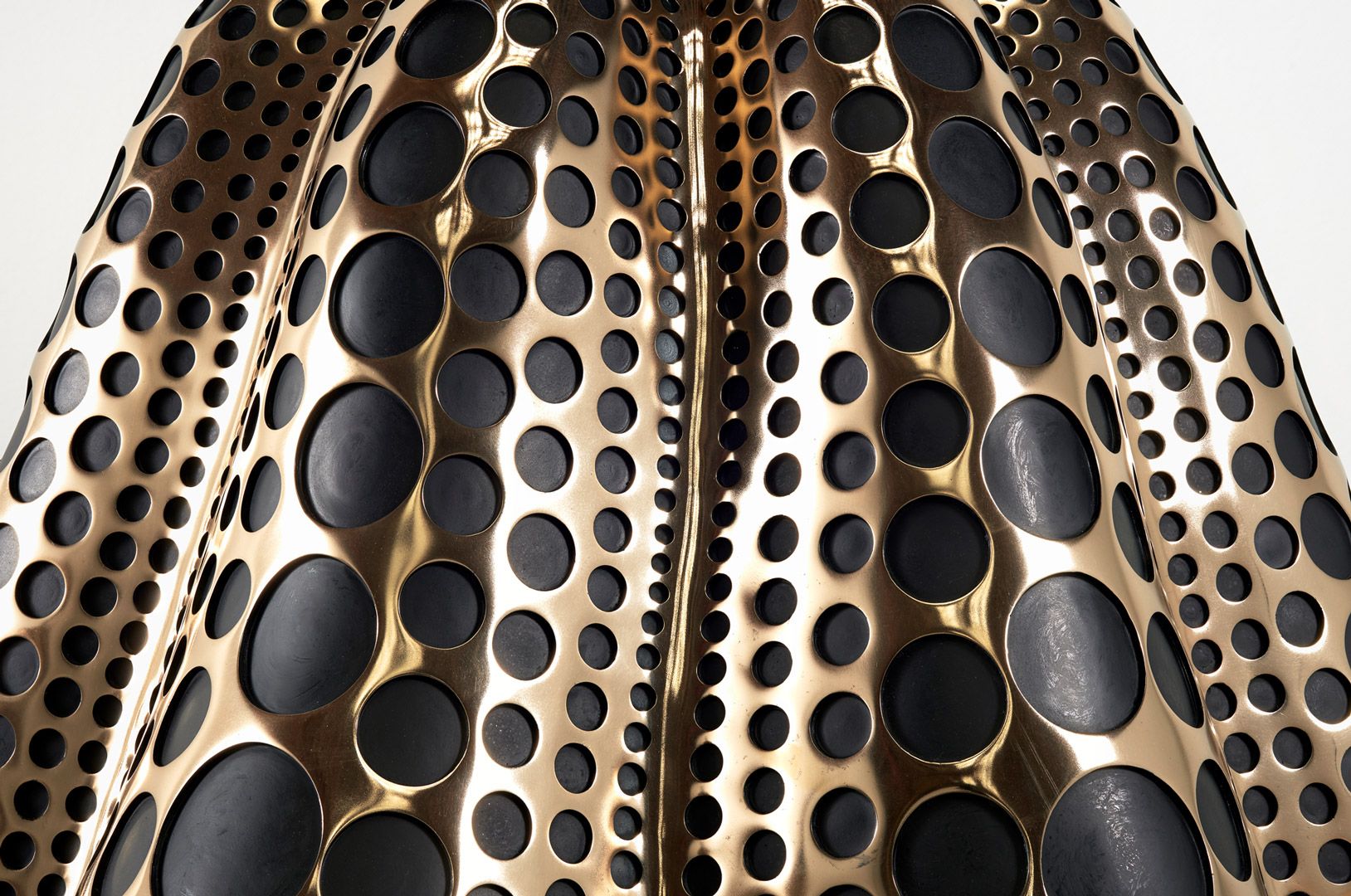 A detail view of a mirror polished bronze, dye, and acrylic lacquer sculpture by Yayoi Kusama, titled Pumpkin (M), dated 2016.