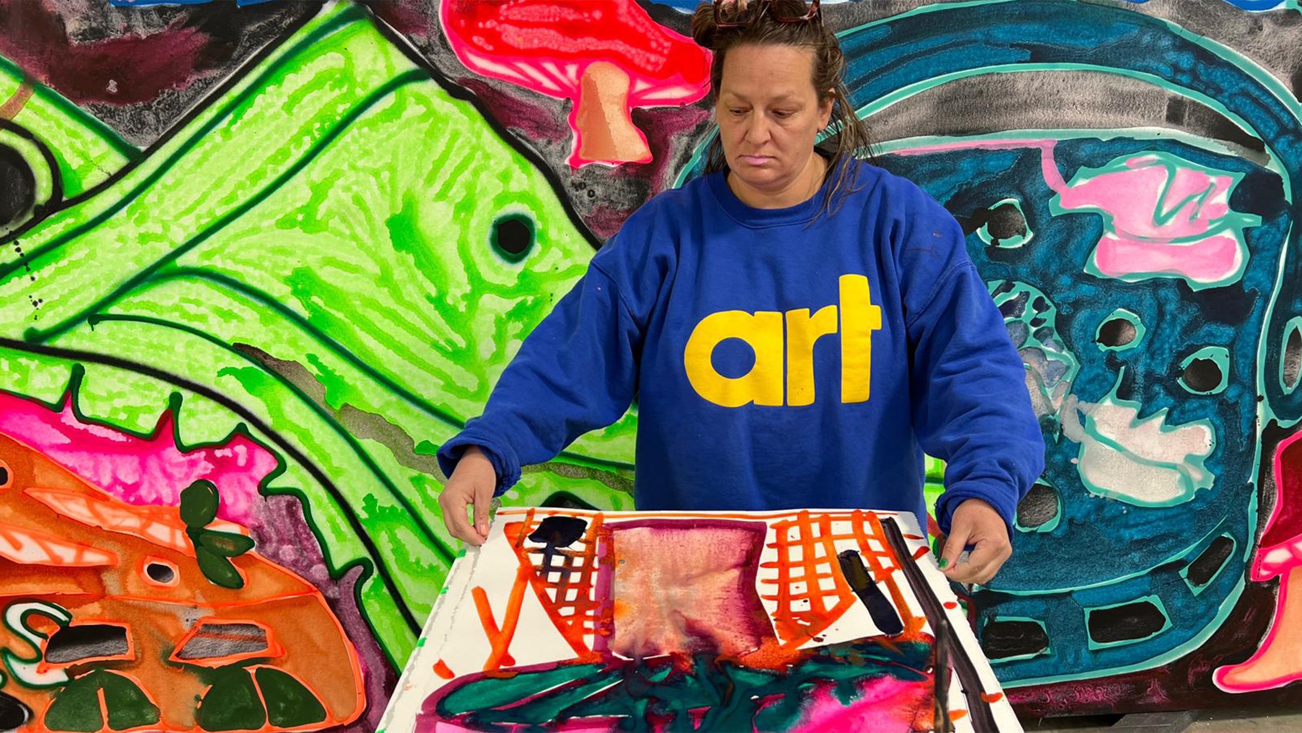 A Photo by Elizabeth Bernhardt of Katherine Bernhardt was inspired by the mushrooms sprouting from DJ and producer Diplo’s limited-edition collaboration with Crocs. Bernhardt in her studio, St. Louis, April 2022. 
